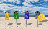 4 poubelles sur une plage : pour les plastiques, le verre, le papier, et, pour les parapluies