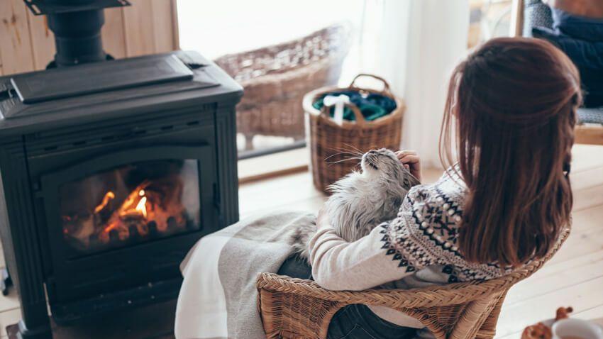 Une femme assise près du feu.